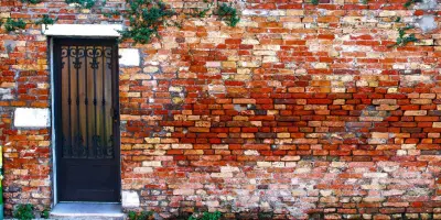picture of a door in a long brick wall